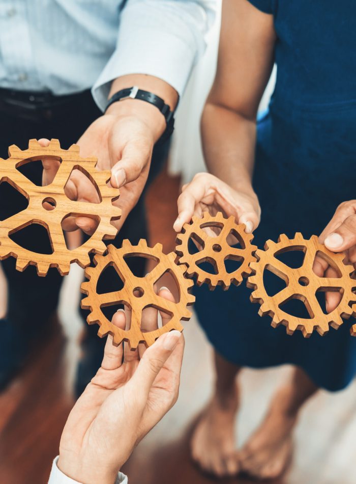 Office worker holding cog wheel as unity and teamwork in corporate workplace concept. Diverse colleague business people showing symbol of visionary system and mechanism for business success. Concord